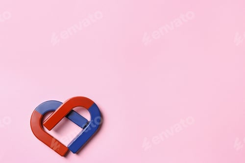 Preview: Red and blue horseshoe magnets on pink background, flat lay. Space for text