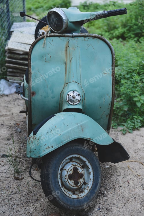 Preview: Vertical shot of an old light blue motorcycle parked on the street