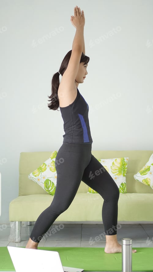 Preview: asian woman practicing yoga at home doing hand warm up