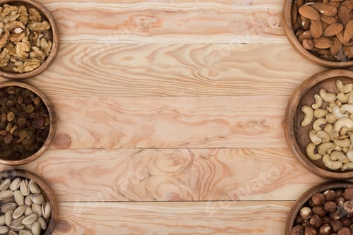 Preview: top view of assorted nuts in bowls on wooden table