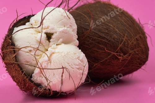 Preview: Vanilla ice cream balls in an empty coconut decorated with mint leaves on a pink background