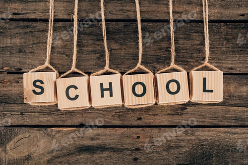 Preview: Top view of alphabet cubes with word school on wooden background