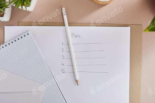 Preview: top view of green plants, envelope, blank notebook, pencils and paper with plan lettering on beige