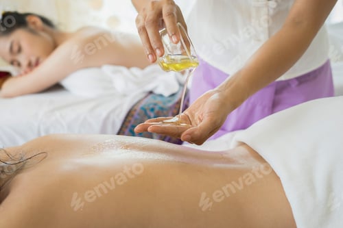 Preview: Beautiful woman having back massage and feeling visibly good during oil massage.