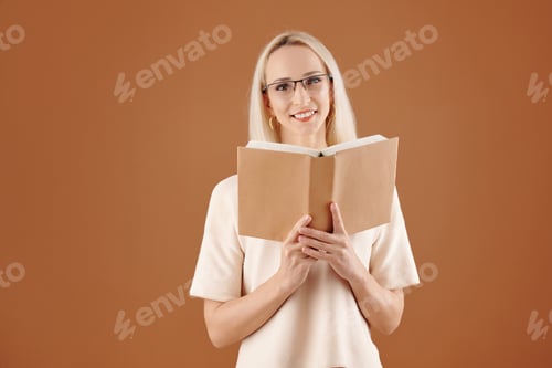 Smiling Woman Reading Book on Brown Background