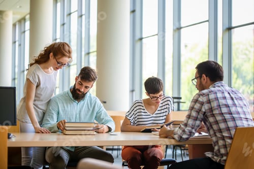 Preview: Happy university students studying with books in library. Group of multiracial people in college