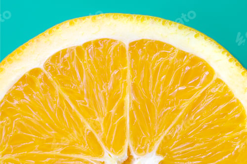 Preview: Top view of a one orange fruit slice on bright background in turquoise green color