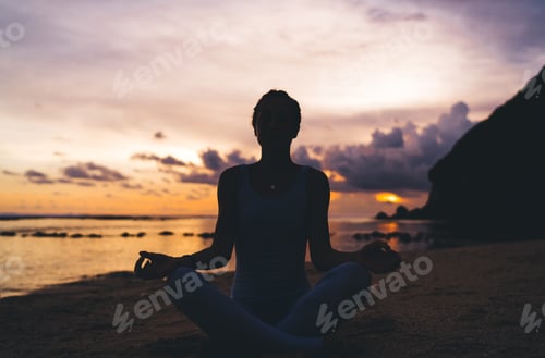Preview: Anonymous woman meditating during sundown