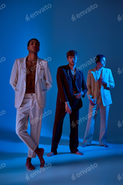 Preview: vertical shot of elegant men in classy suits standing and posing with neon lighting on their faces