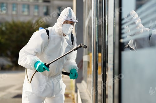 Preview: Sanitation worker in hazmat suit disinfecting public building during coronavirus epidemic.