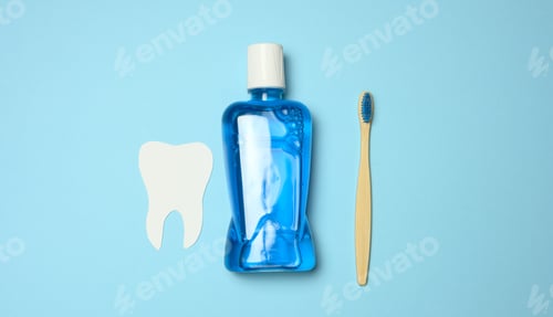 Preview: Plastic bottle with mouthwash, wooden toothbrush on blue background
