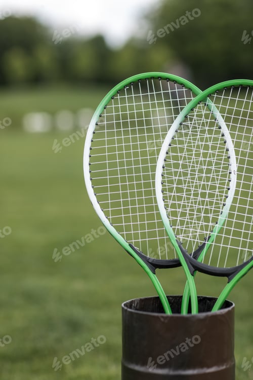 Preview: Close-up view of two badminton racquets in container outdoors