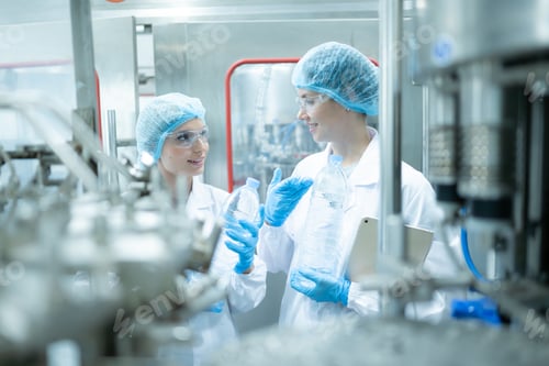 Preview: Female quality control worker inspecting water bottle on production line in drinking water factory
