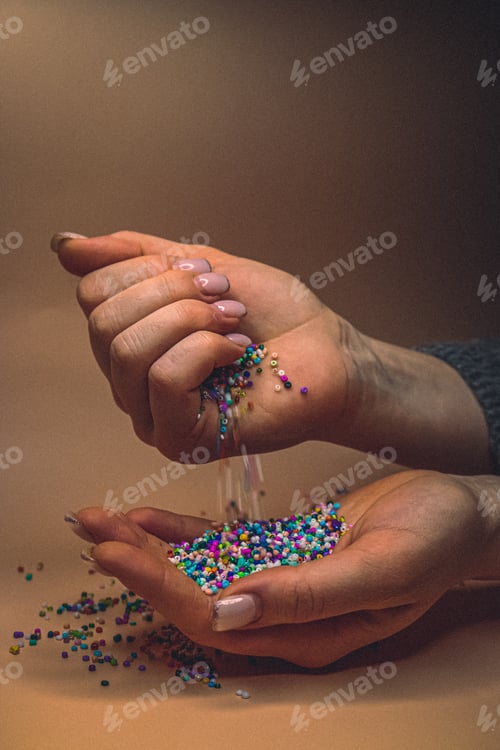 Preview: Multicolored beads in the hands of a girl