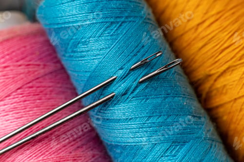 Preview: macro shot of needle inserted in the color thread rolls