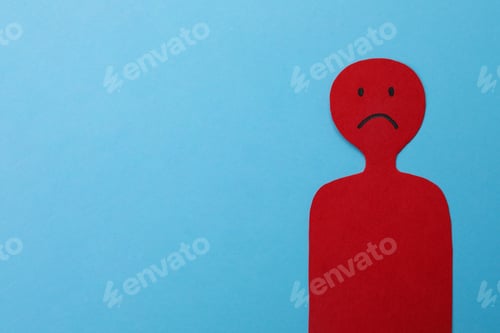 Preview: Red paper cutout of person with sad face on light blue background, space for text. Stress management