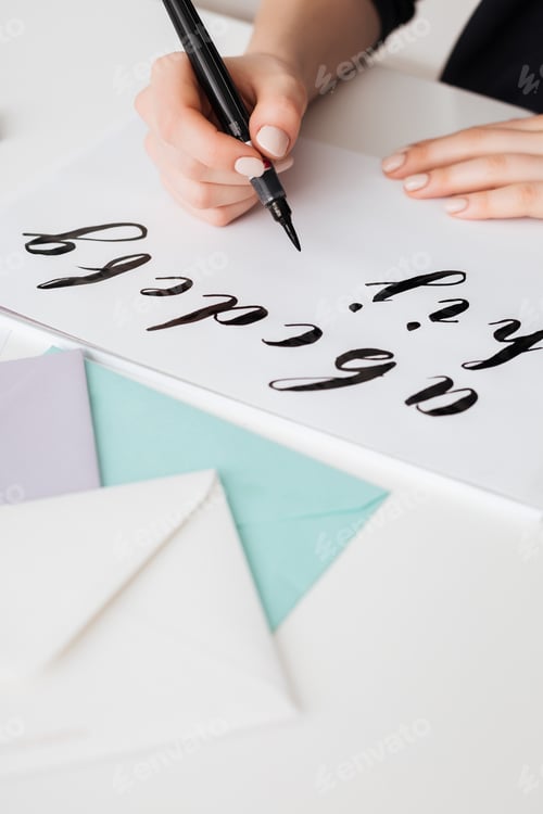 Preview: Close up photo of young woman hands writing alphabet on paper on desk isolated
