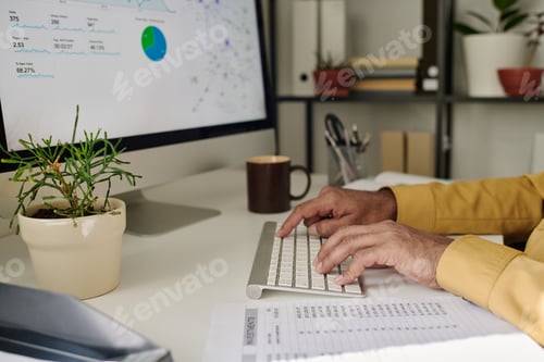 Preview: Working on Business Report in Office with Green Plants on Desk