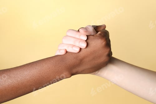 Preview: Stop racism. People of different skin colors holding hands on beige background, closeup
