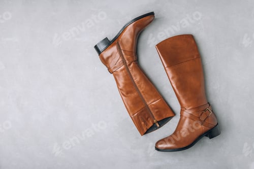 Preview: Boots. Women's brown leather high long boots on gray background. Top view.