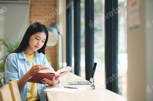 Preview: Young asian woman sitting and reading book.
