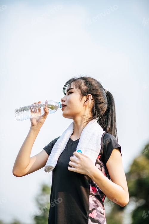 Preview: Women stand to drink water after exercise