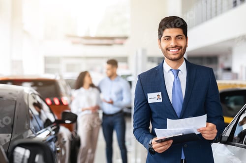 Preview: Charismatic arab man sales assistant posing over auto showroom