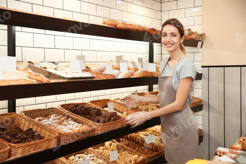 Preview: Beautiful woman near showcase with pastries in bakery shop