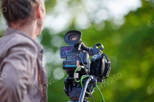 Preview: Rear view to man videographer recording outdoor movie about nature on professional camera, TV crew
