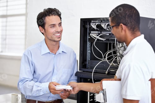 Preview: Two men smiling at each other in a working environment. One passing a note to another man.