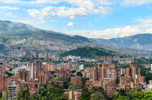 Preview: Red brick buildings on lush green mountains under pale blue skies - Medellin, Colombia