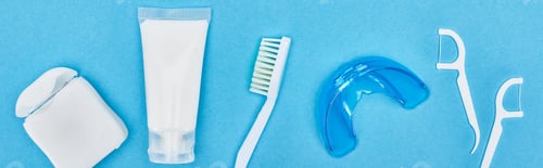 Preview: panoramic shot of toothbrush, toothpaste and teeth floss near retainer and floss sticks isolated on