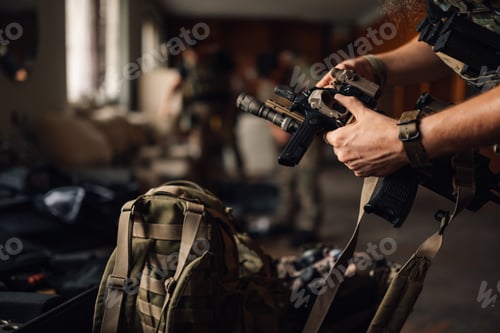 Preview: Close up of airsoft fighter preparing his sniper for war game.