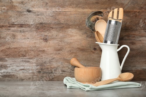 Preview: Different kitchen utensils on grey table against wooden background. Space for text