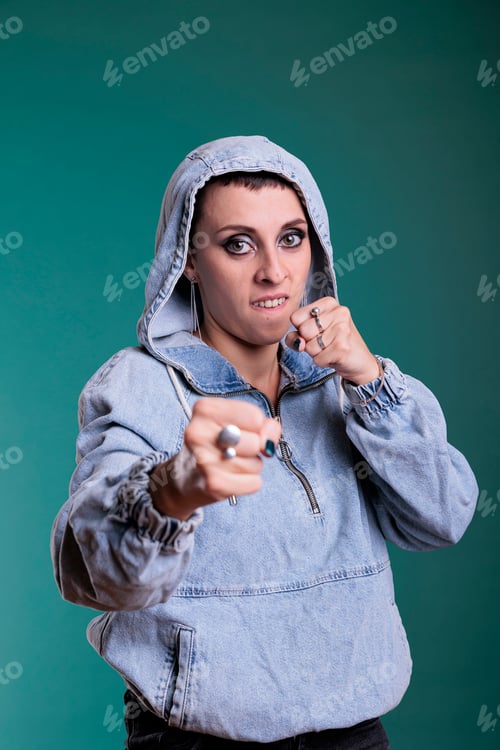 Preview: Angry woman boxer with hood on standing in self defense pose