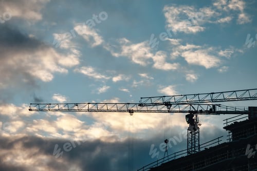 Preview: Construction cranes work on creation site against sky background