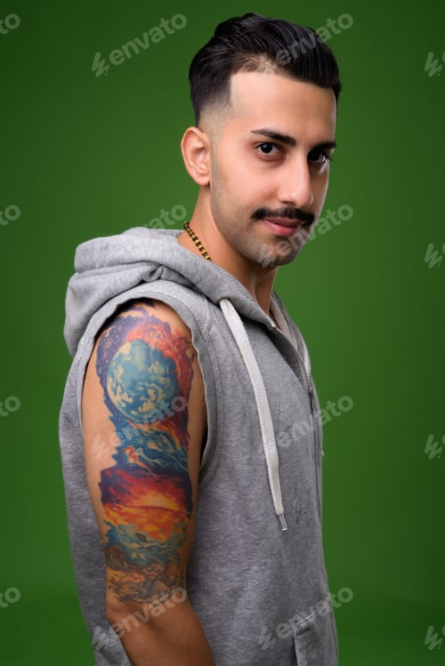 Preview: Young handsome Iranian man with mustache against green backgroun