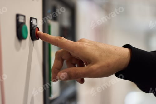 Preview: Hand Pressing a Red Emergency Stop Button on a Control Panel