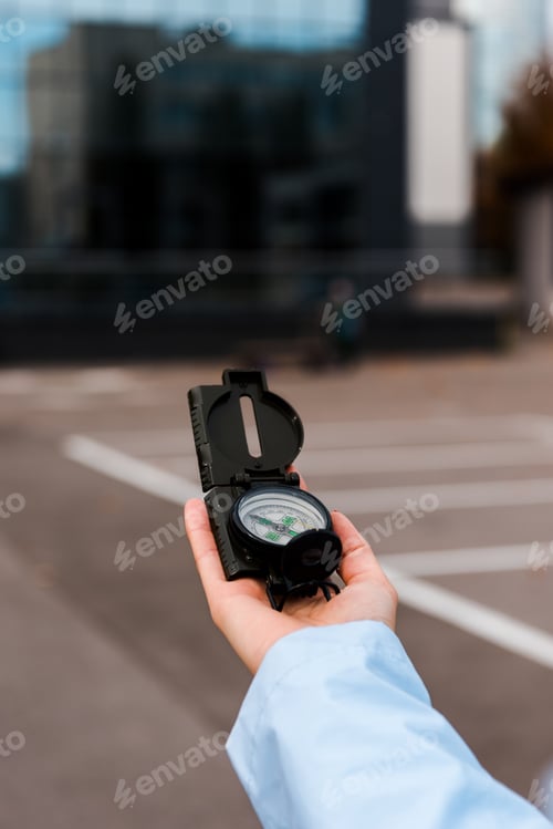 Preview: cropped view of woman holding compass outside