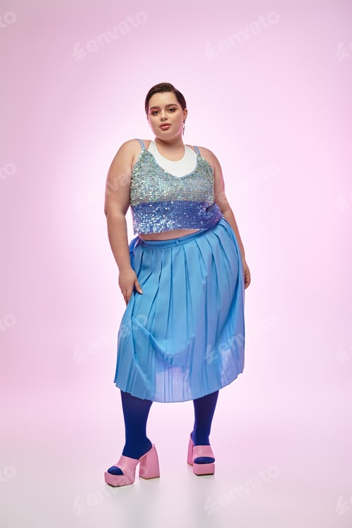 Preview: Charming young woman in stylish outfit poses gracefully against a vibrant pink background
