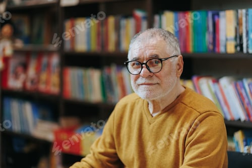 Preview: Bookish Haven Front View of Wise Elderly Man in Bookstore