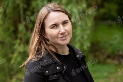 Preview: young woman walking in the park in the summer in rainy weather