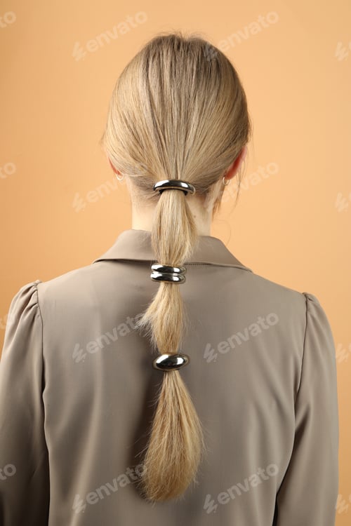 Preview: Woman with beautiful hair ties on beige background, back view