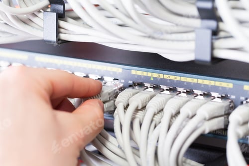 Preview: IT consultant connects a network cable into switch in datacenter