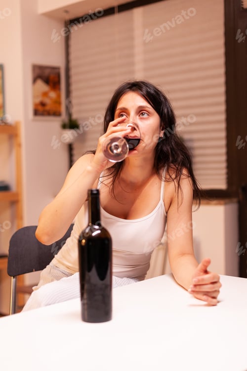 Preview: Sad woman drinking red wine