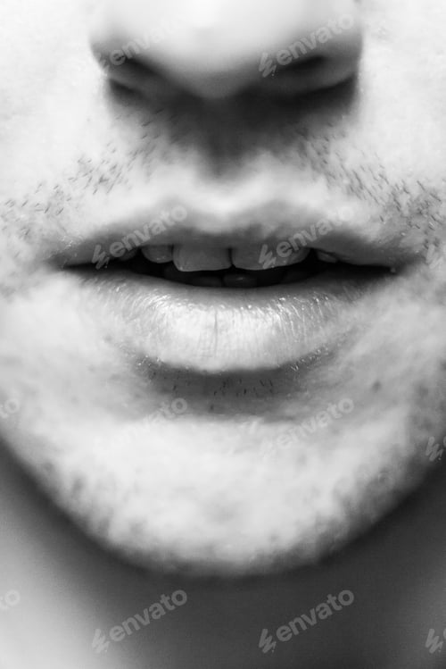 Preview: Vertical shot of a male mouth with white teeth and some beard