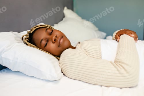 Preview: Afro american female keeping eyes closed while sleeping at the bedroom