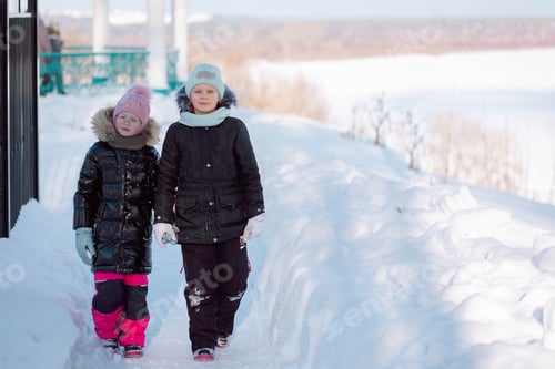 Preview: Little girls play with snow and walks outdoors on winter sunny frosty day