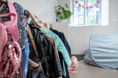 Preview: Children clothes hanging on rack in kindergarten