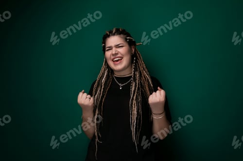 Preview: Woman With Dreadlocks Standing in Front of Green Wall